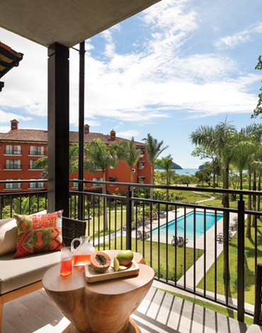 Balcony view of shimmering resort pool and palm trees