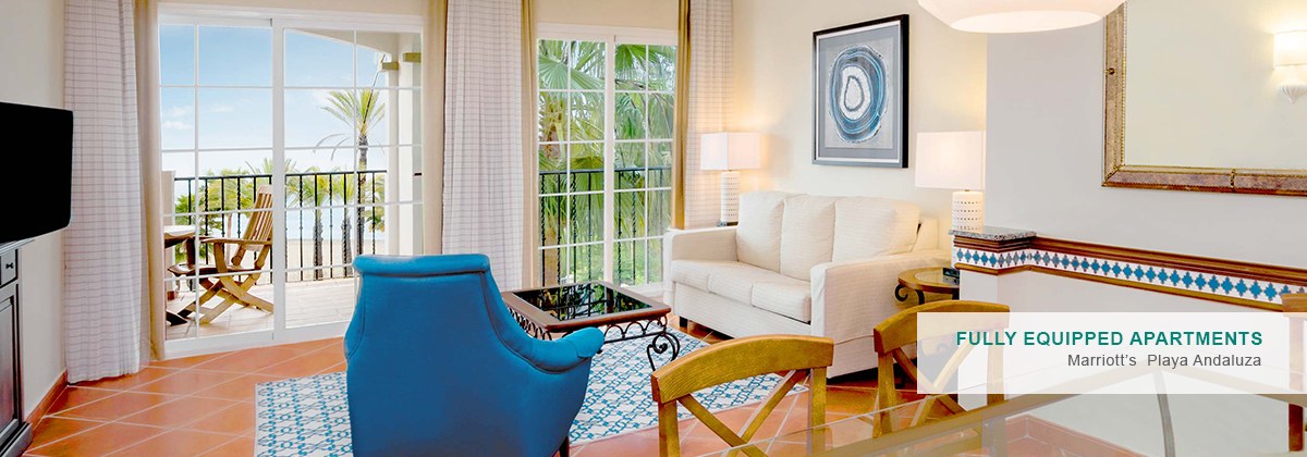 A spacious living room with a balcony overlooking the sea.