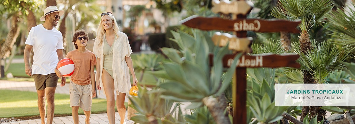 Une famille en vacances se promenant à travers des jardins tropicaux