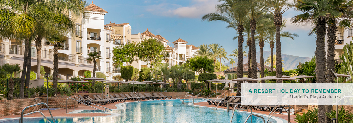 An aerial view of a premium resort hotel in Spain with balconies overlooking the sea.